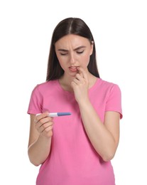 Confused woman holding pregnancy test on white background