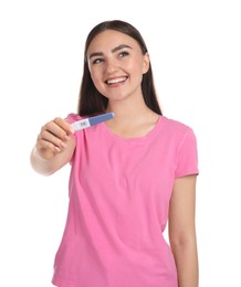 Happy woman holding pregnancy test on white background