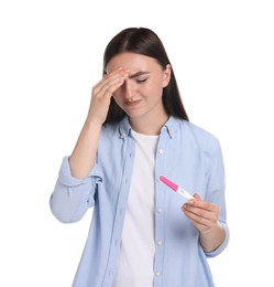 Confused woman holding pregnancy test on white background