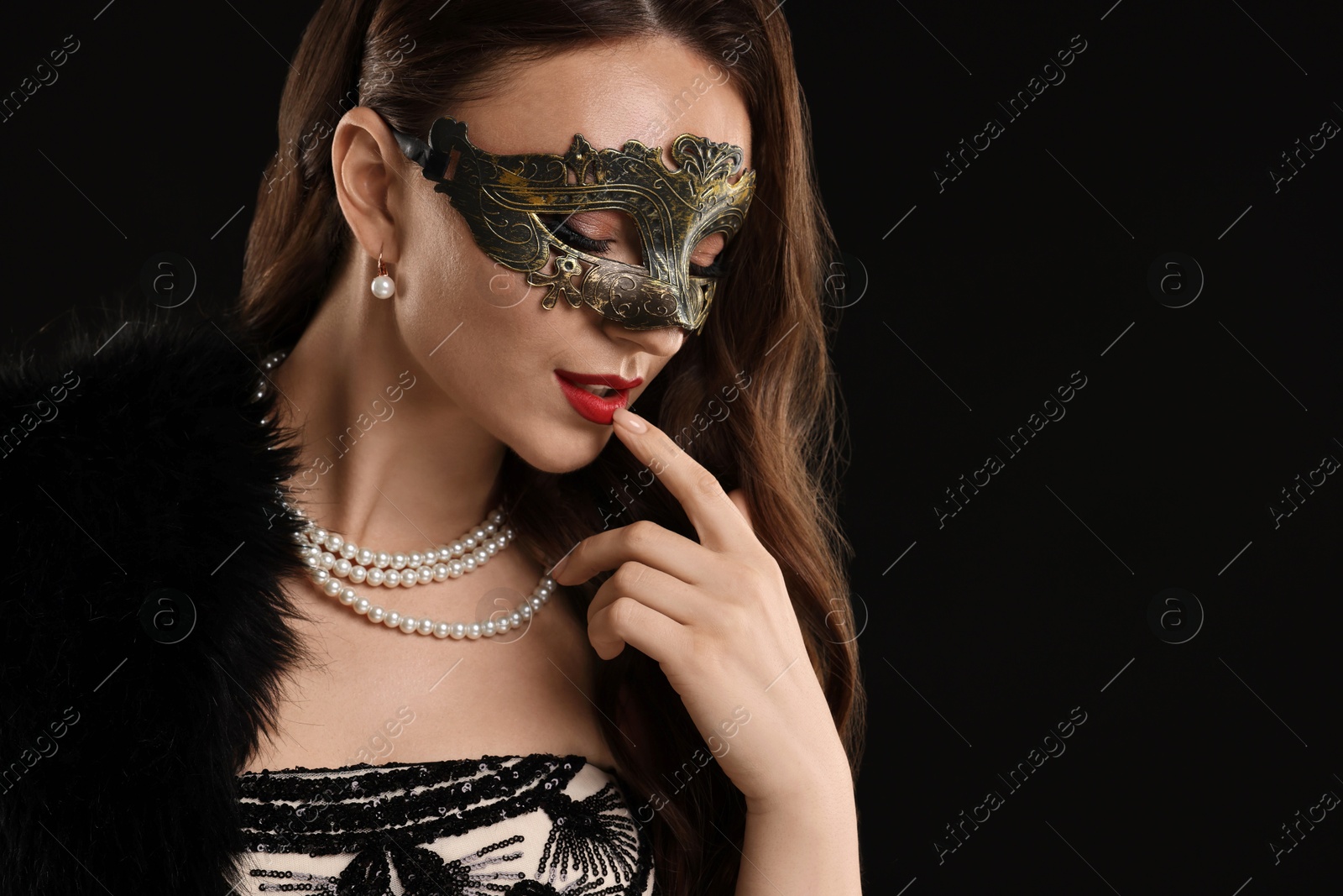 Photo of Beautiful woman wearing carnival mask on black background. Space for text