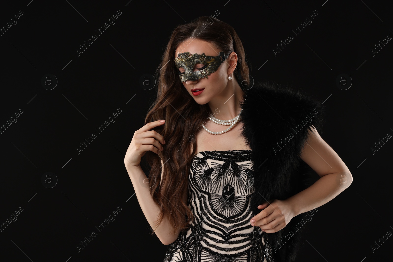 Photo of Beautiful woman wearing carnival mask on black background. Space for text