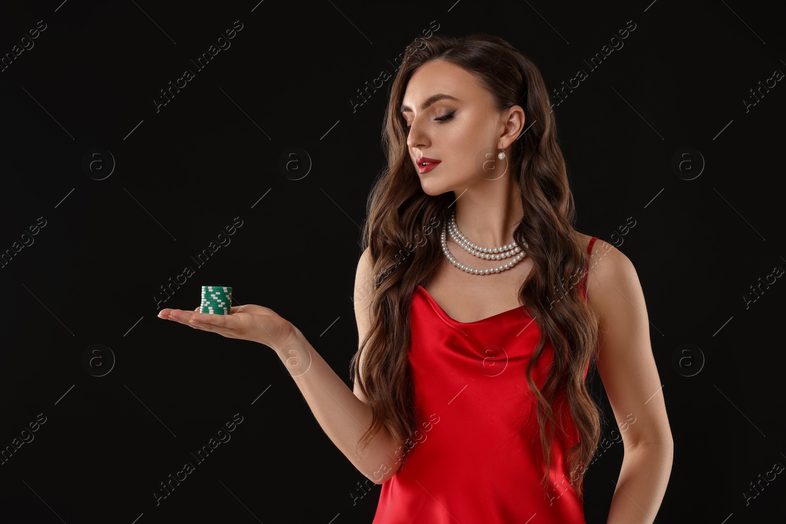 Photo of Charming woman with poker chips on black background