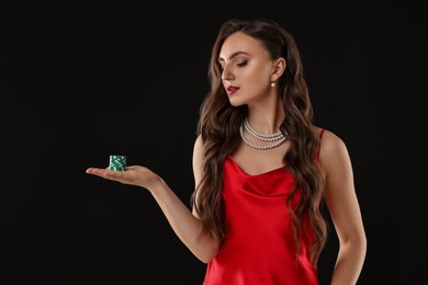 Photo of Charming woman with poker chips on black background