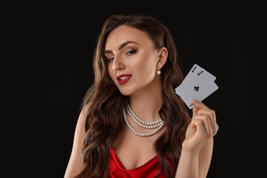 Photo of Poker game. Charming woman with playing cards on black background