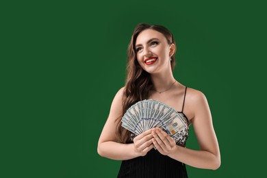 Smiling woman with dollar banknotes on green background. Space for text