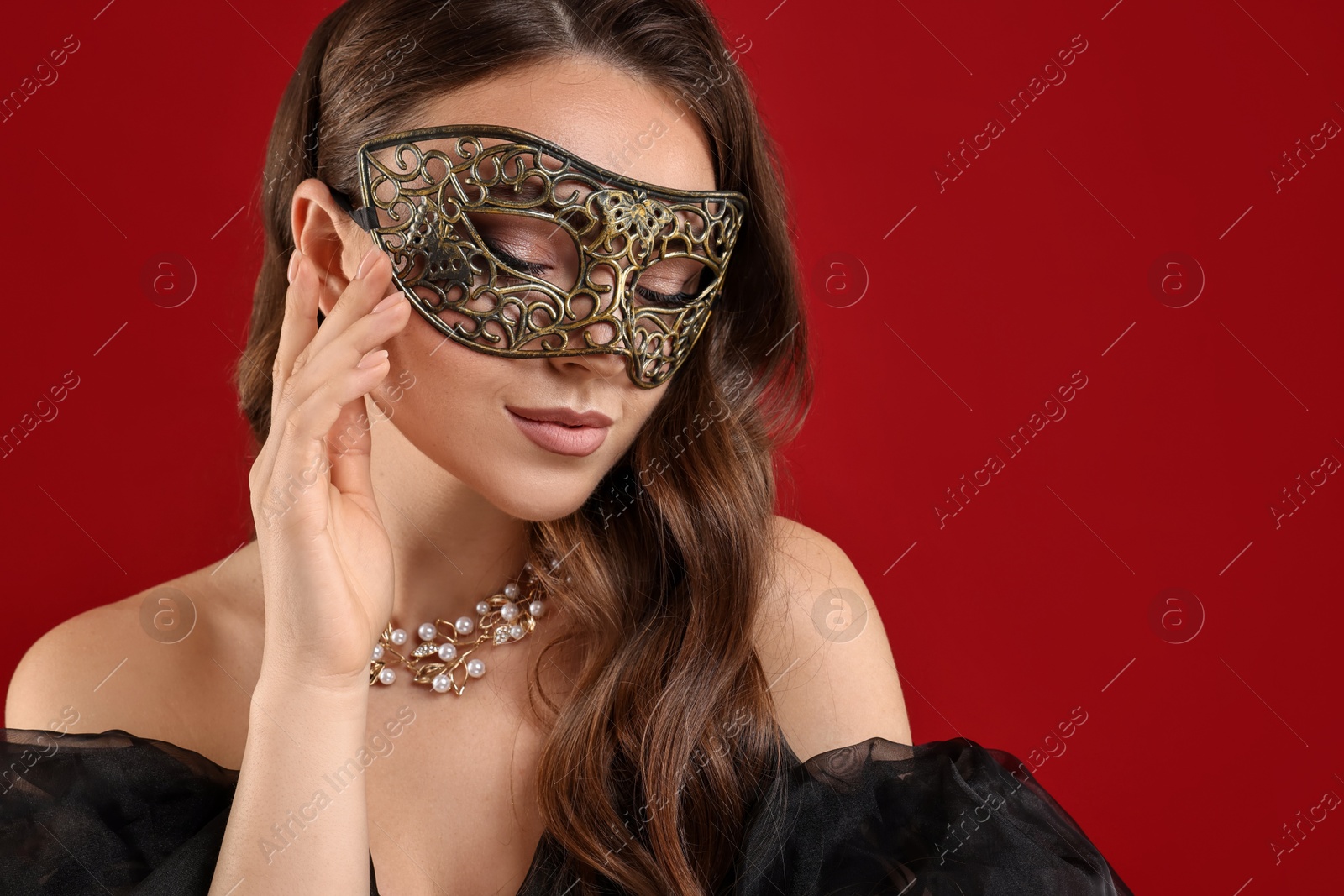 Photo of Beautiful woman wearing carnival mask on red background. Space for text