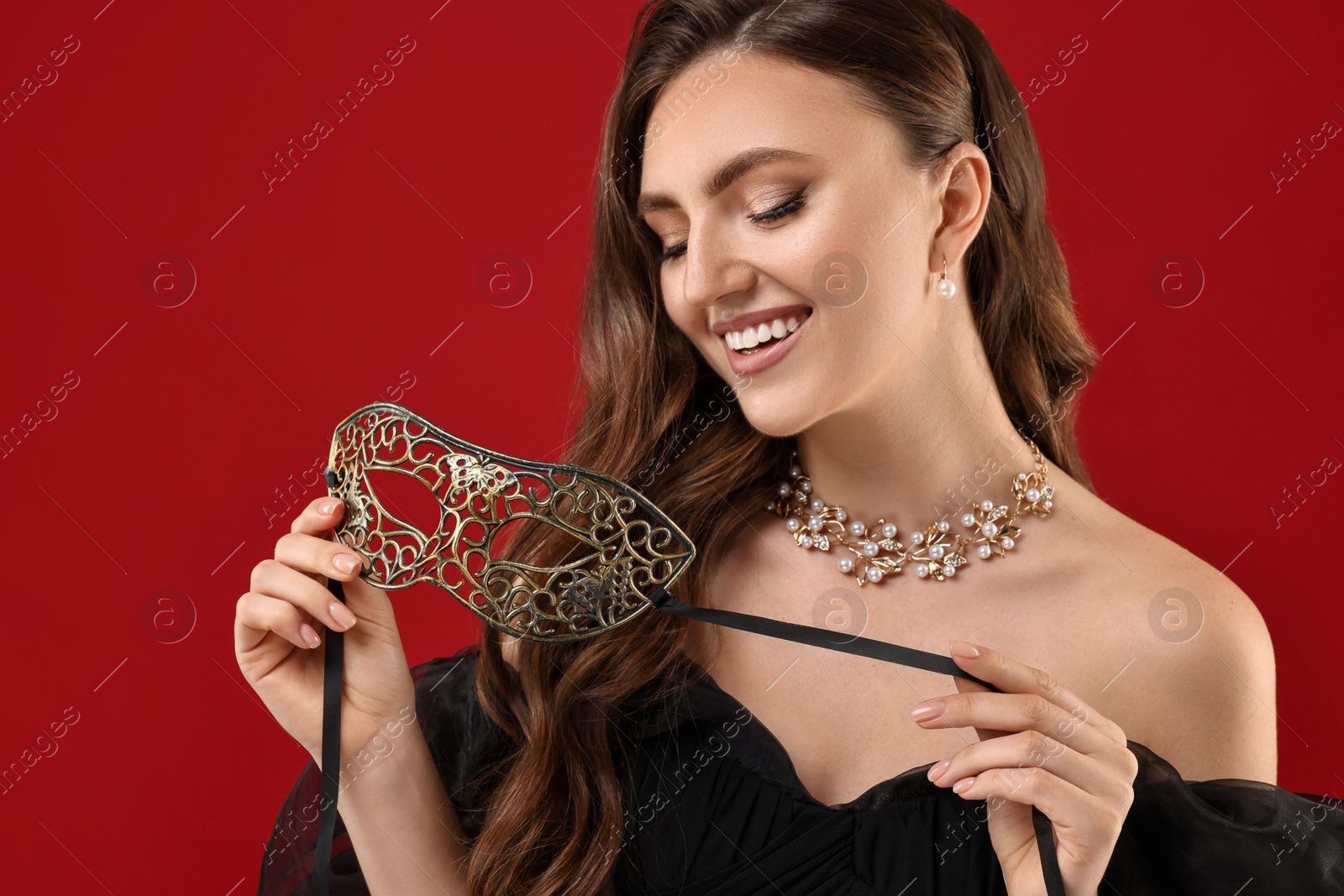 Photo of Happy woman with carnival mask on red background