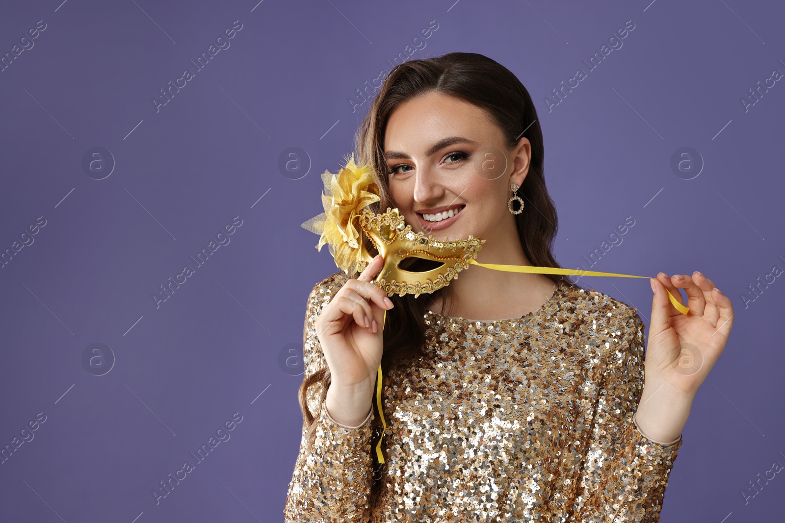 Photo of Smiling woman with carnival mask on purple background. Space for text