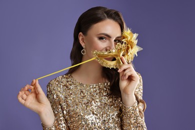 Photo of Beautiful woman with carnival mask on purple background