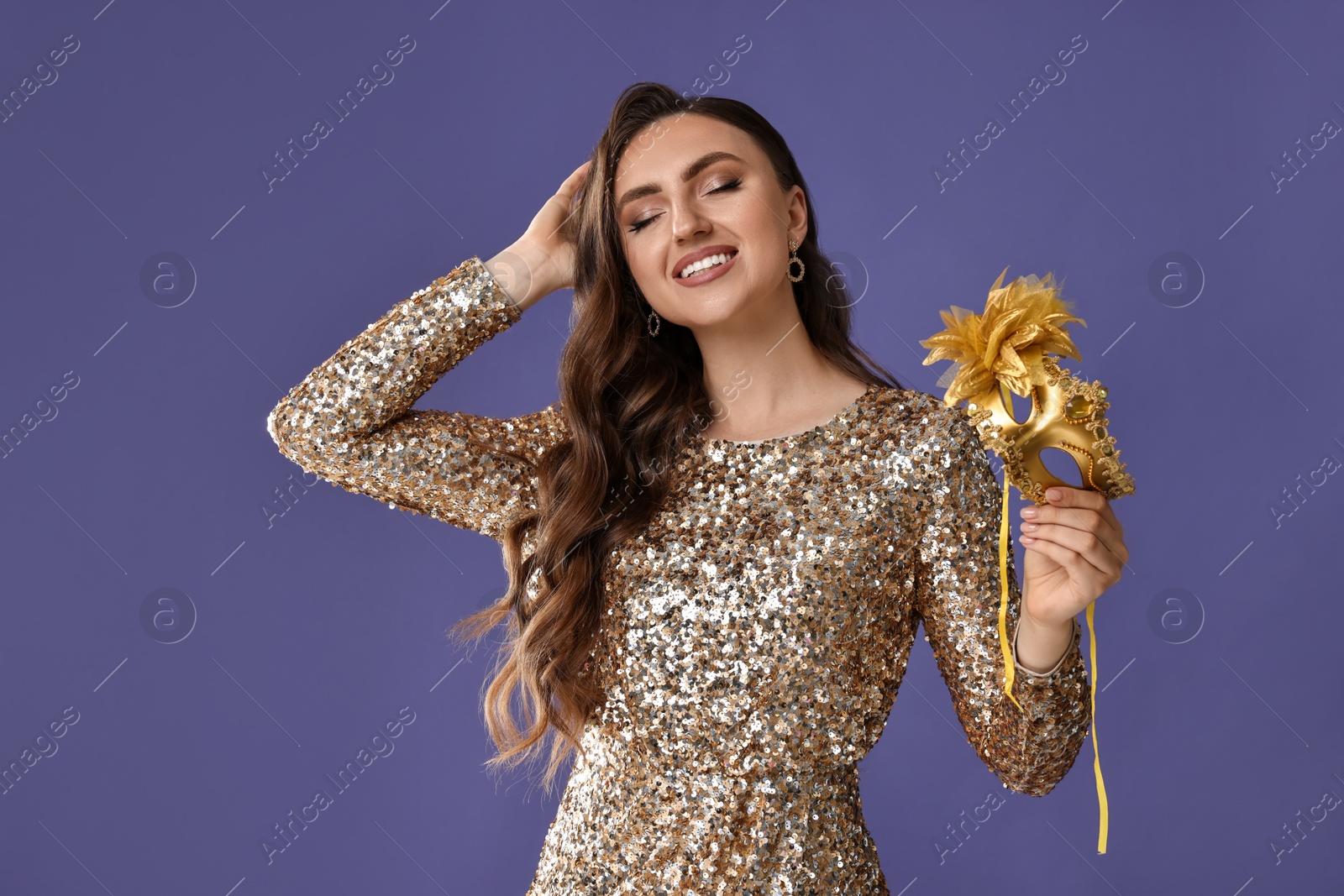 Photo of Smiling woman with carnival mask on purple background