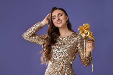 Smiling woman with carnival mask on purple background