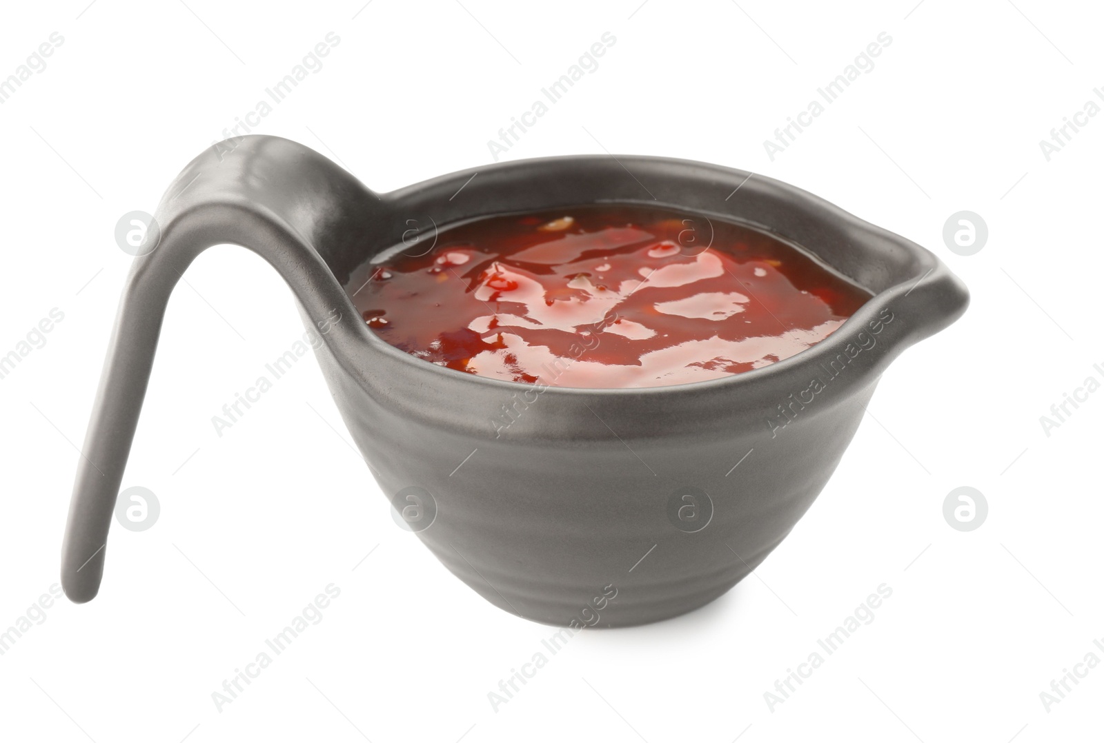 Photo of Hot chili sauce in gravy boat isolated on white