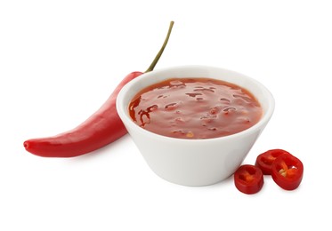 Photo of Hot chili sauce in bowl and pepper isolated on white