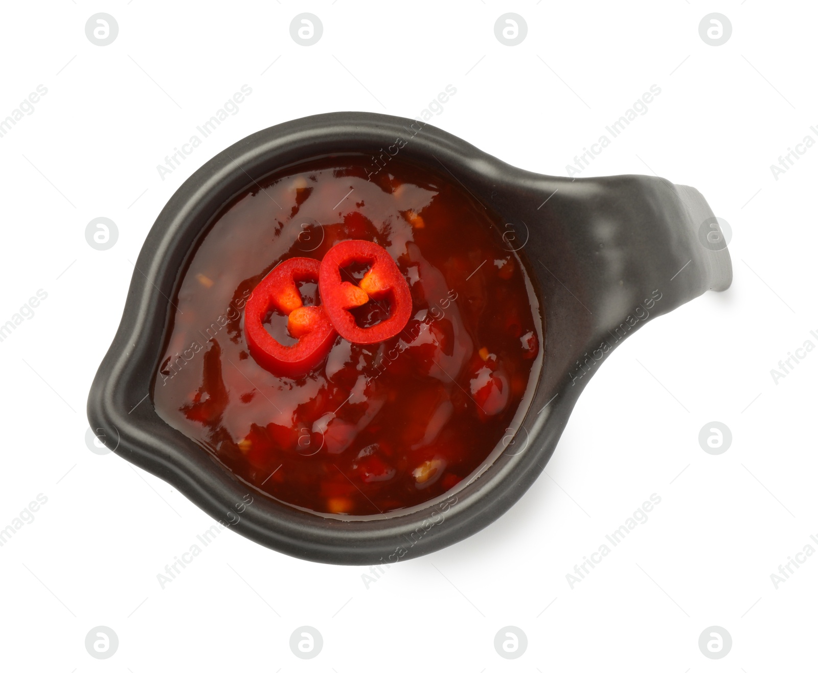 Photo of Hot chili sauce in gravy boat isolated on white, top view