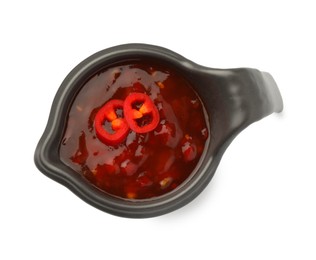 Photo of Hot chili sauce in gravy boat isolated on white, top view