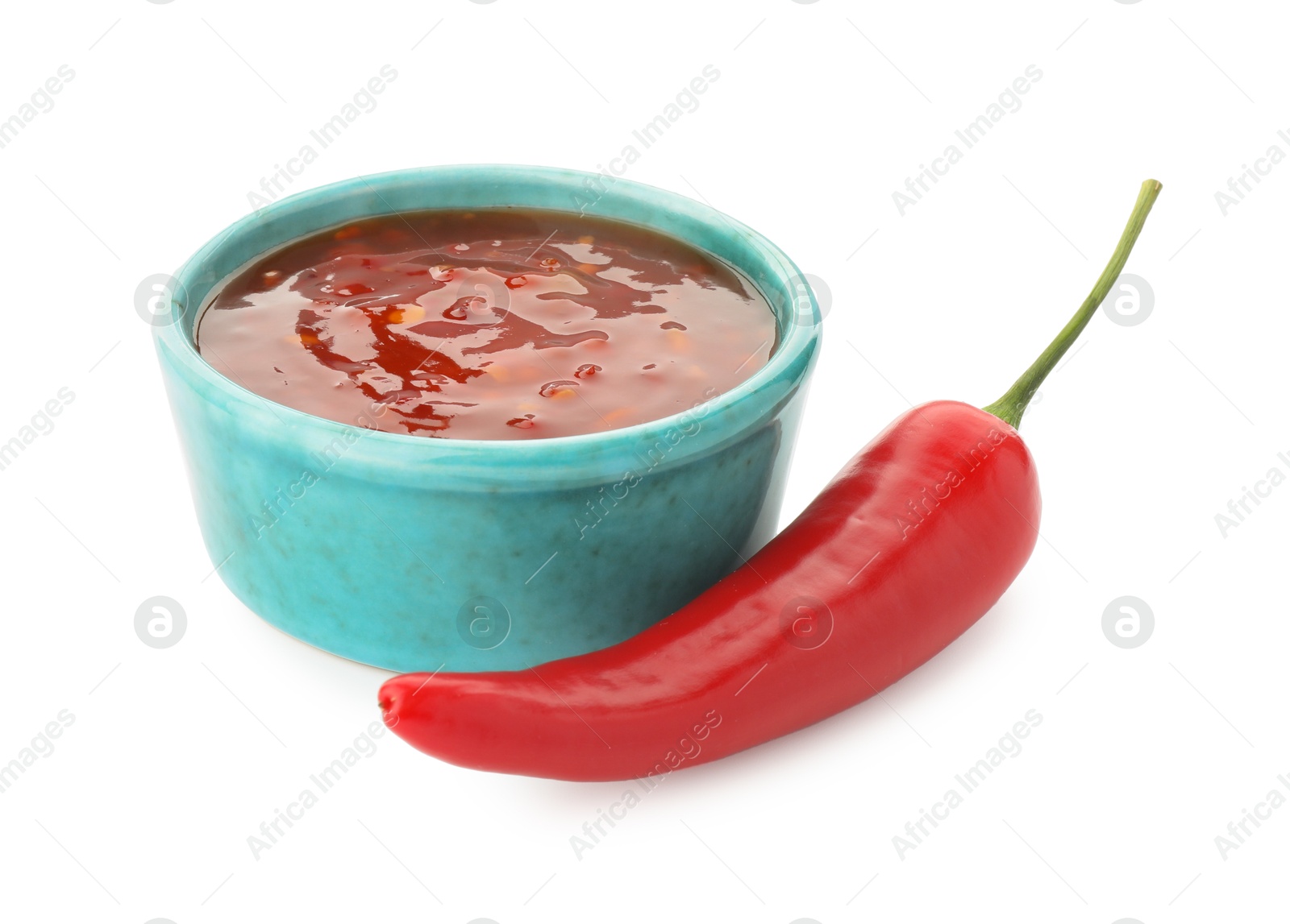 Photo of Hot chili sauce in bowl and pepper isolated on white