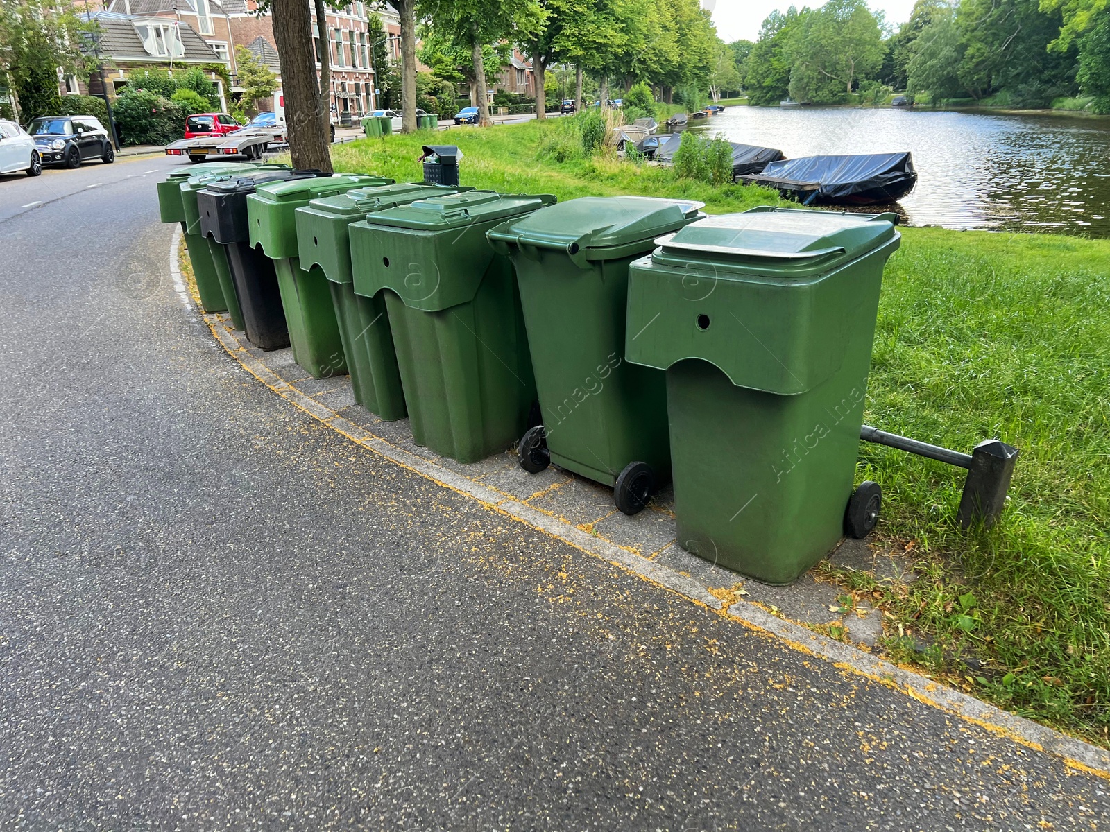 Photo of Many green trash bins on city street