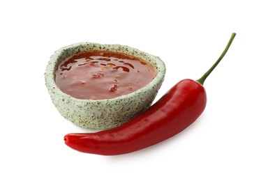 Photo of Hot chili sauce in bowl and pepper isolated on white