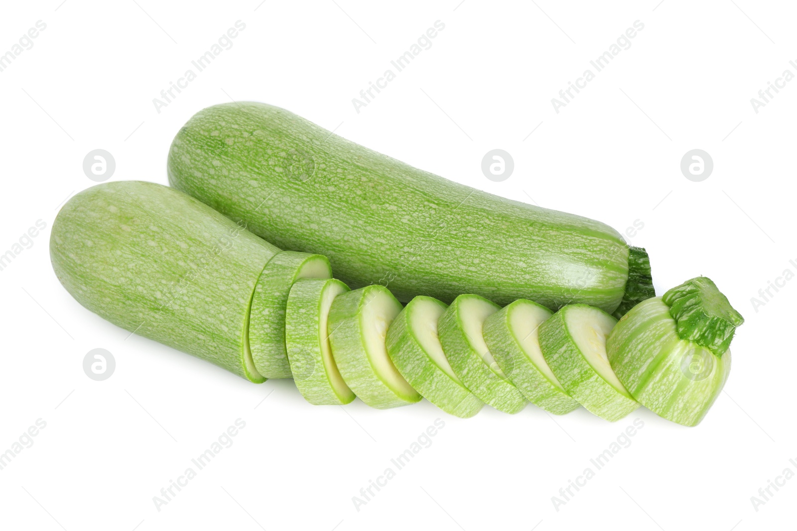 Photo of Fresh whole and cut zucchinis isolated on white, above view