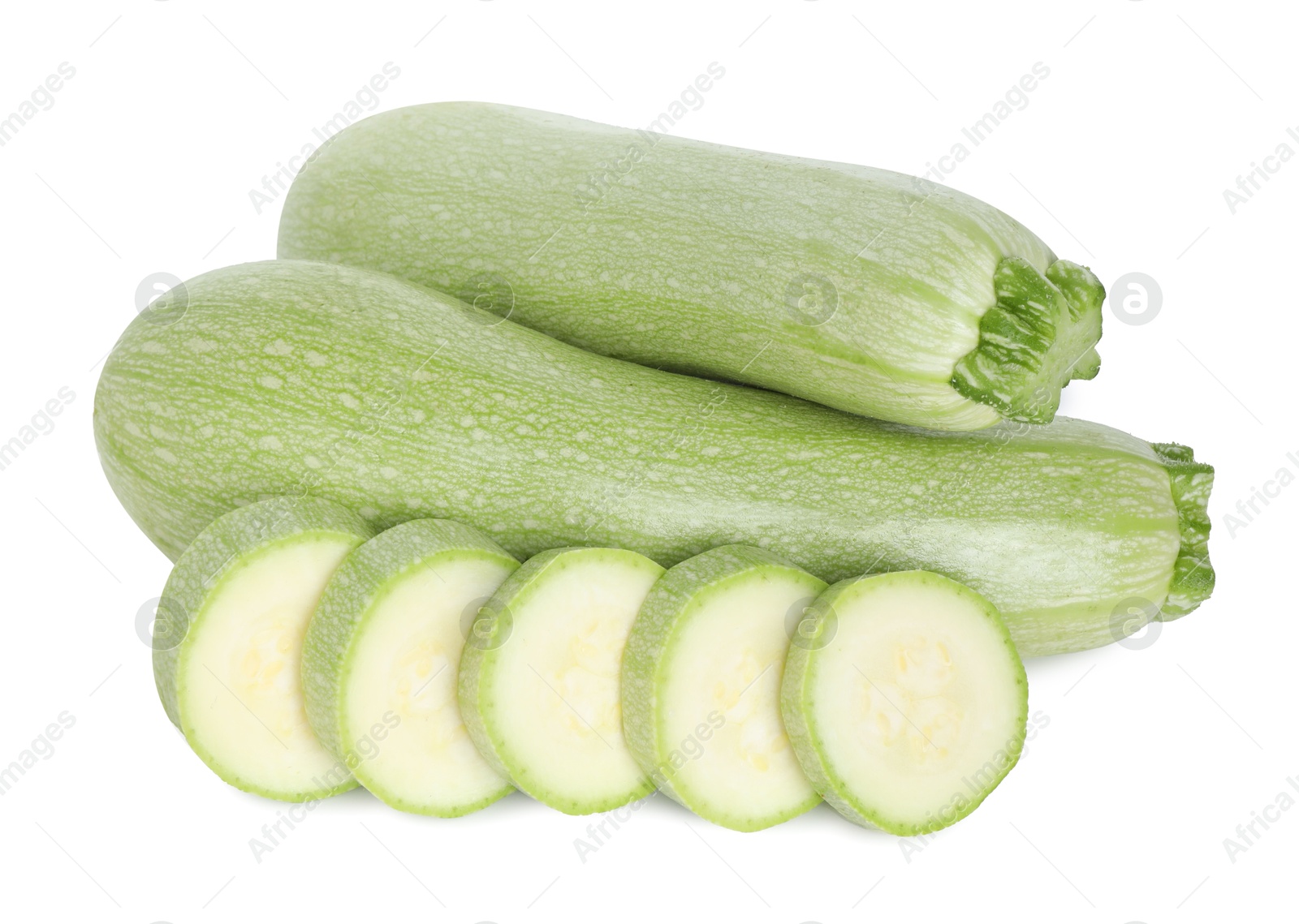 Photo of Fresh whole and cut zucchinis isolated on white, above view