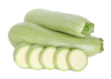 Photo of Fresh whole and cut zucchinis isolated on white, above view