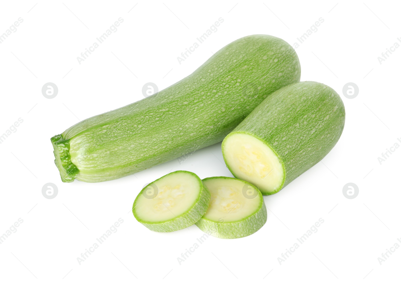 Photo of Fresh whole and cut zucchinis isolated on white, above view