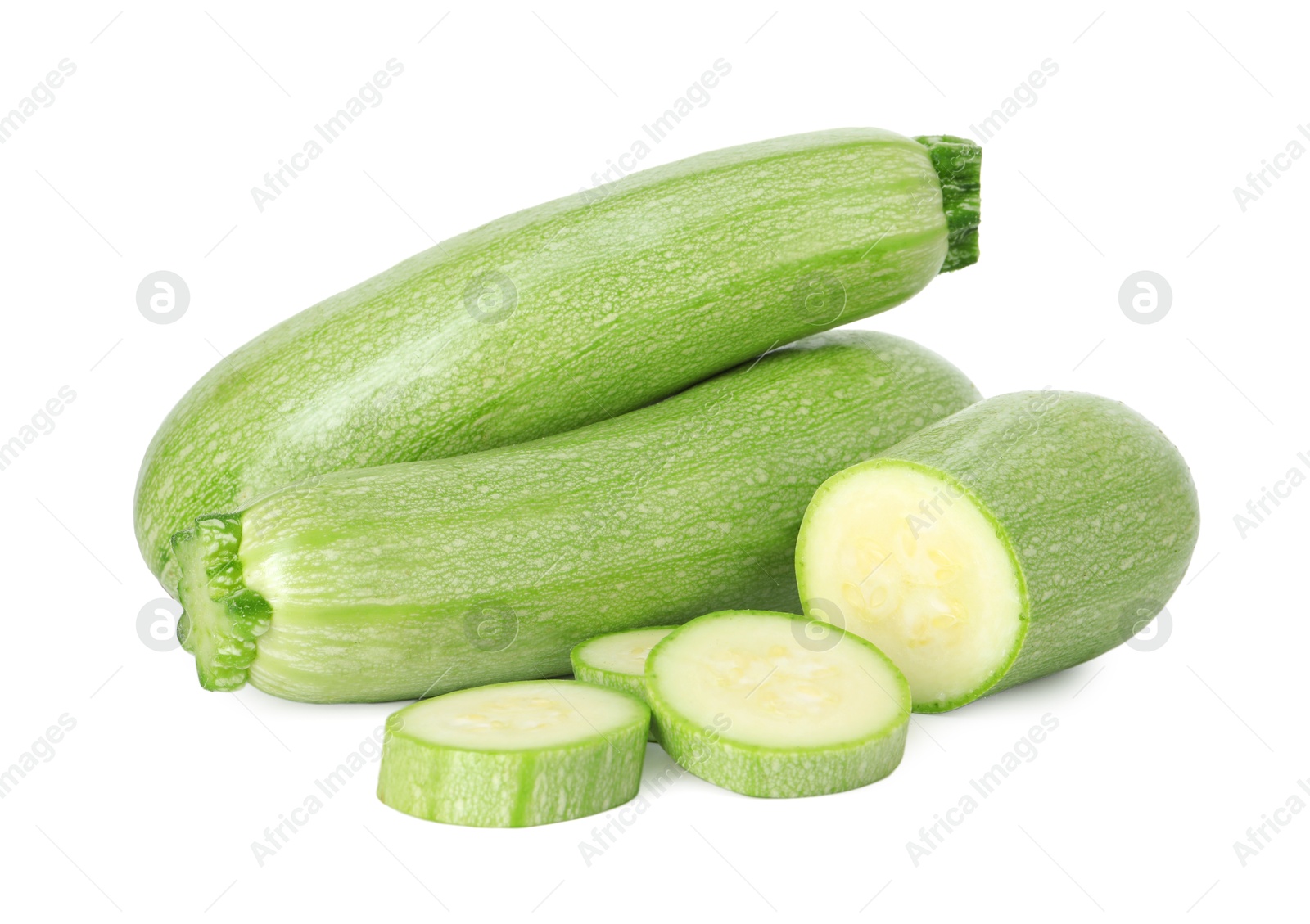 Photo of Fresh whole and cut zucchinis isolated on white