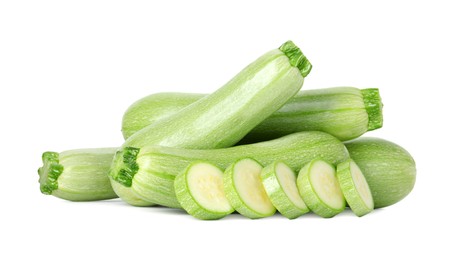 Photo of Fresh whole and cut zucchinis isolated on white