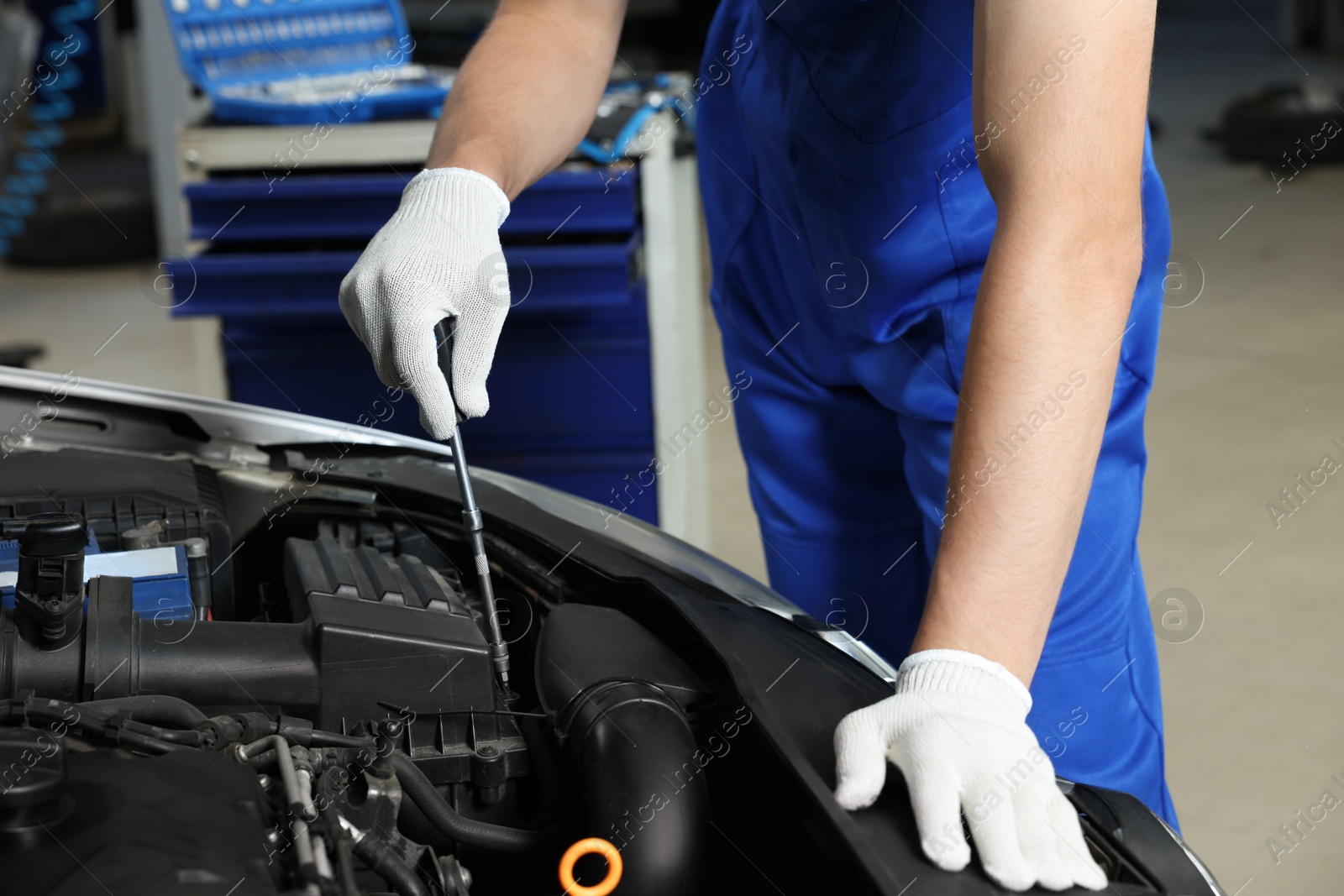 Photo of Auto mechanic fixing car at automobile repair shop, closeup