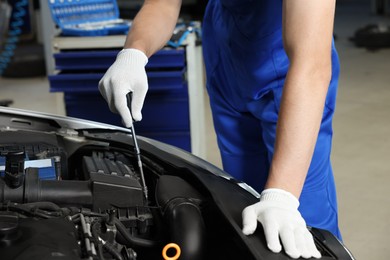 Photo of Auto mechanic fixing car at automobile repair shop, closeup