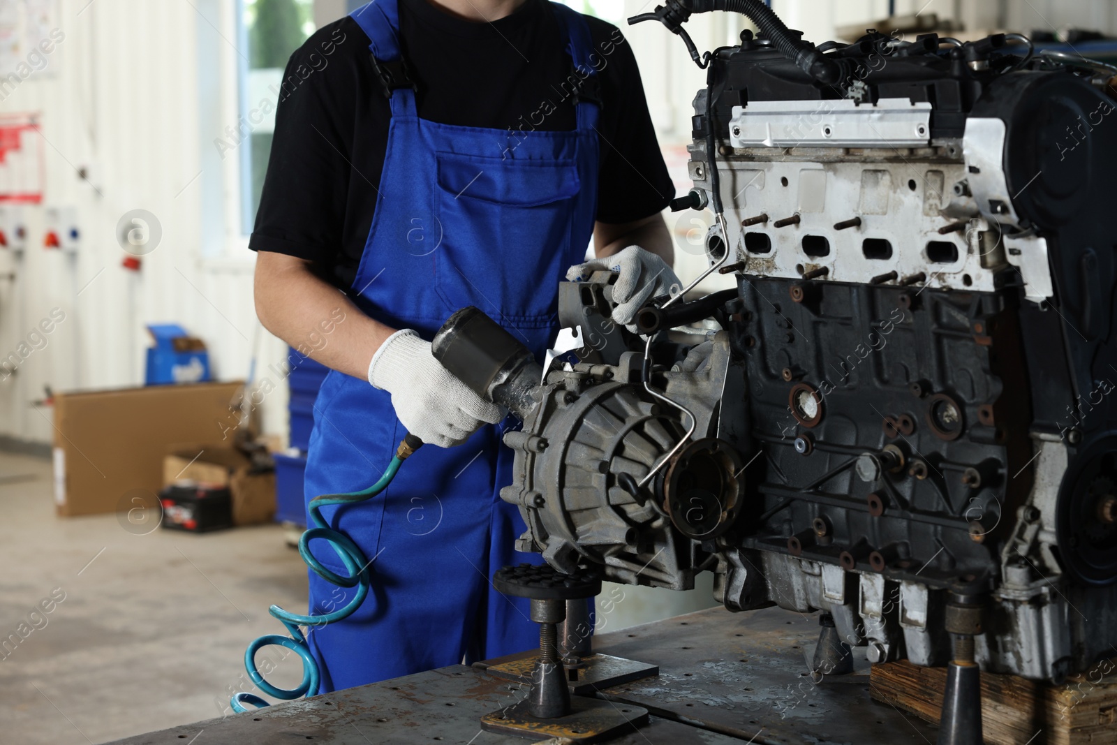 Photo of Auto mechanic fixing motor at automobile repair shop, closeup. Car diagnostic