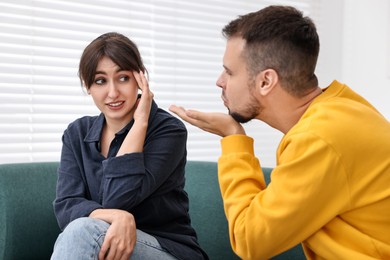 Man sending air kiss to embarrassed woman at home