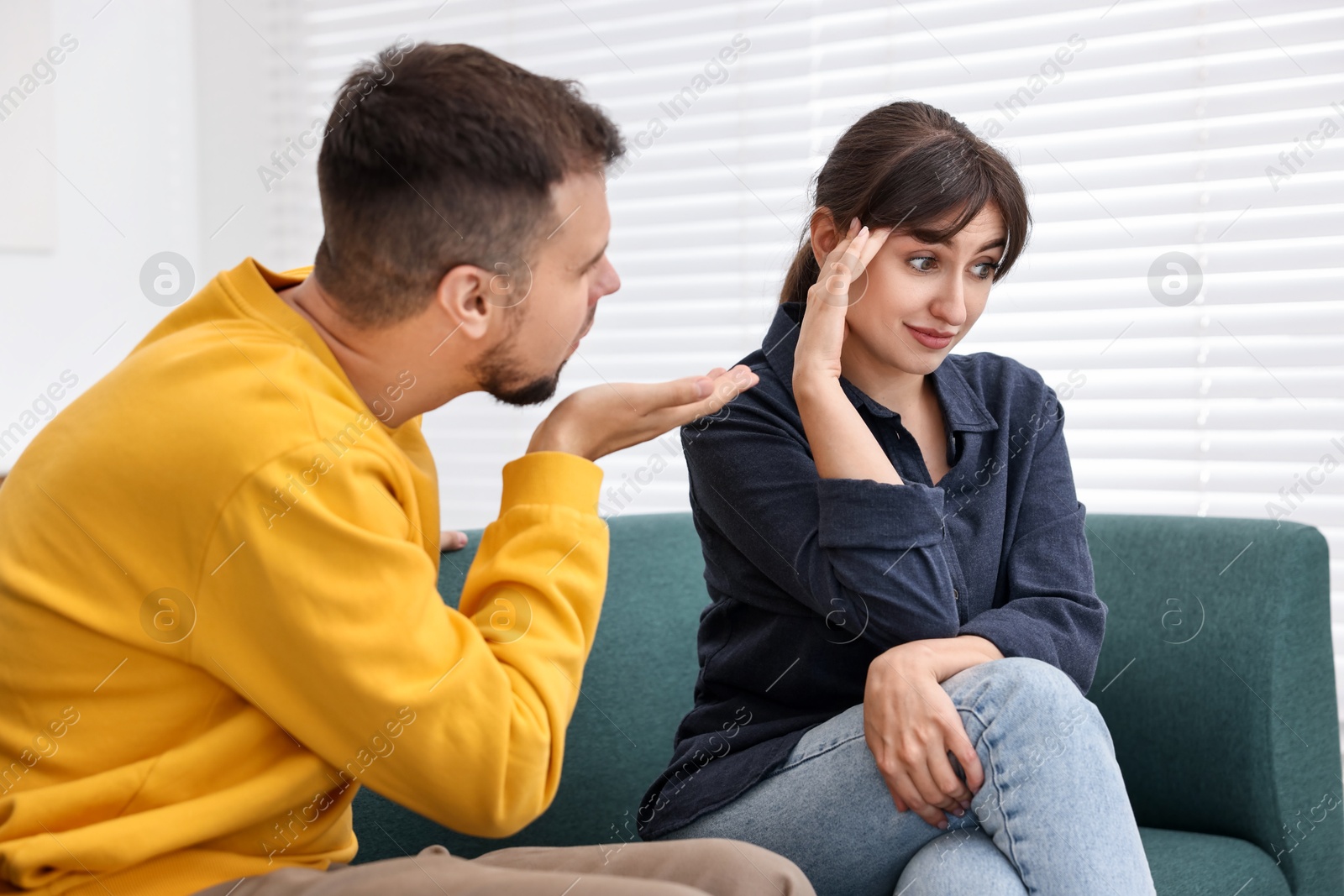 Photo of Man sending air kiss to embarrassed woman at home