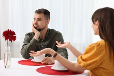 Bad date. Obsessive woman talking to embarrassed man at table indoors