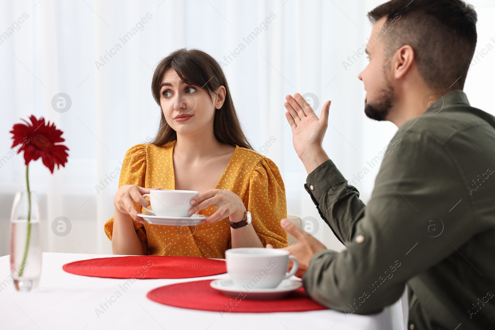 Photo of Embarrassing date. Obsessive man talking to bored woman at table indoors