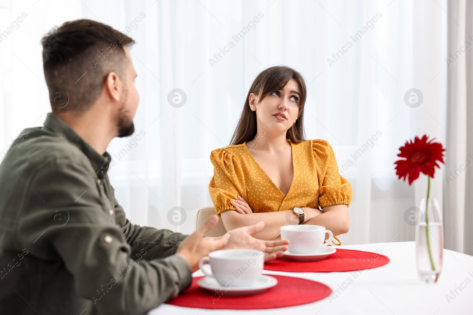 Photo of Embarrassing date. Obsessive man talking to bored woman at table indoors