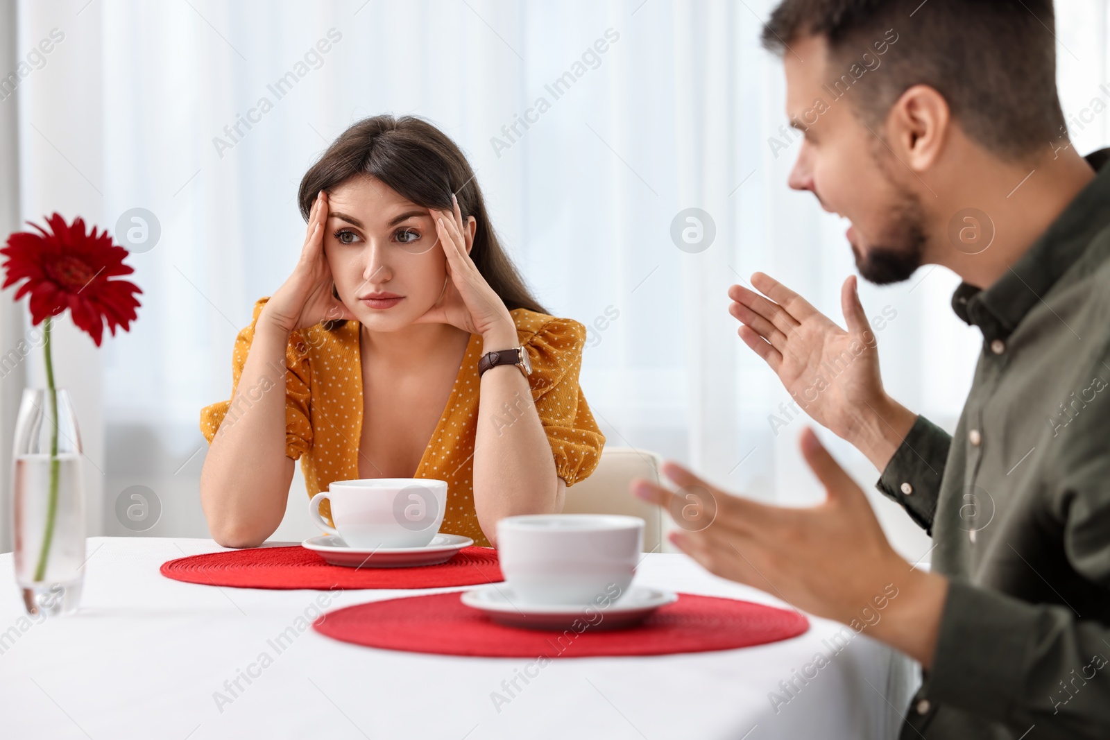 Photo of Embarrassing date. Obsessive man talking to bored woman at table indoors