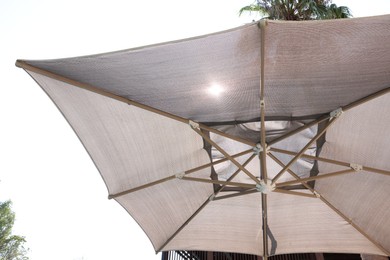 Photo of Open beach umbrella on sunny day, closeup