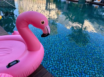 Photo of Outdoor swimming pool with clear water and inflatable float in shape of flamingo at luxury resort