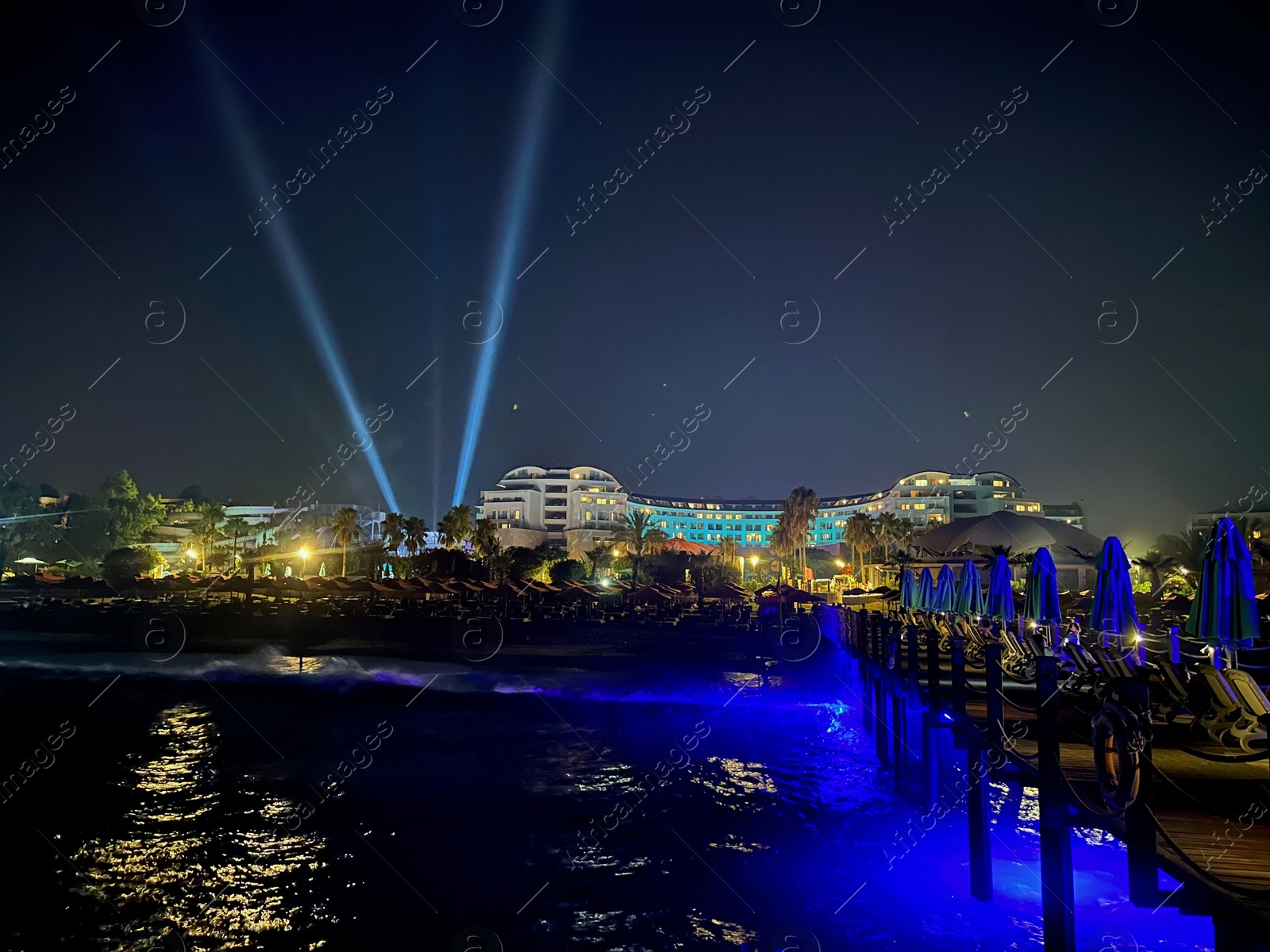 Photo of Beautiful view of night cityscape with sea and illuminated buildings