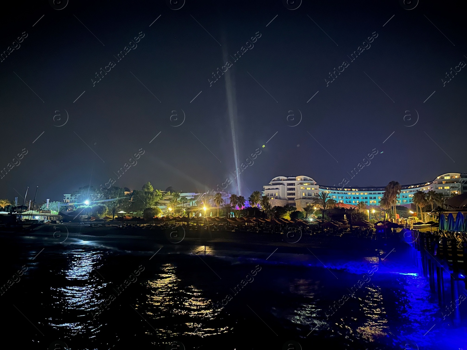 Photo of Beautiful view of night cityscape with sea and illuminated buildings