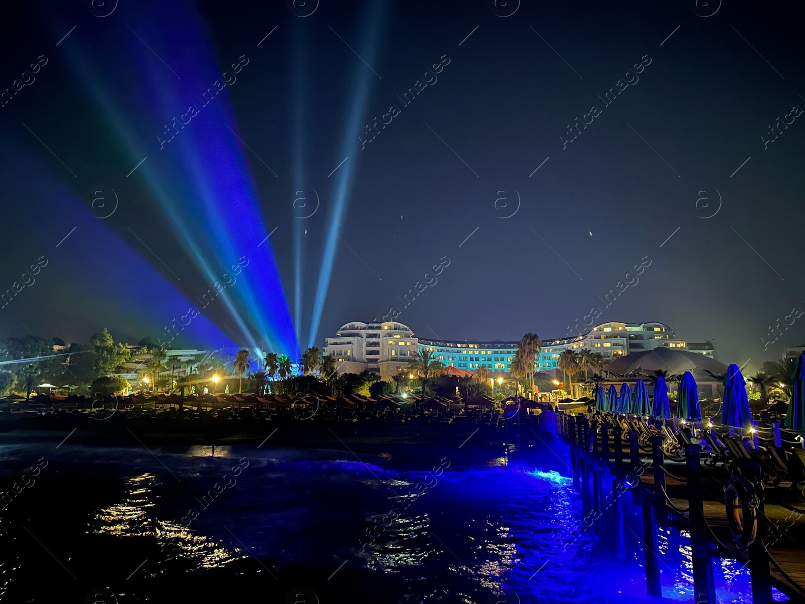 Photo of Beautiful view of night cityscape with sea and illuminated buildings