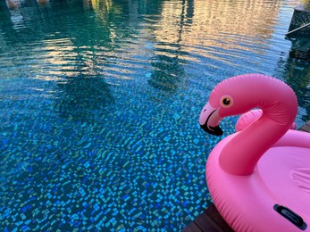 Outdoor swimming pool with clear water and inflatable float in shape of flamingo at luxury resort