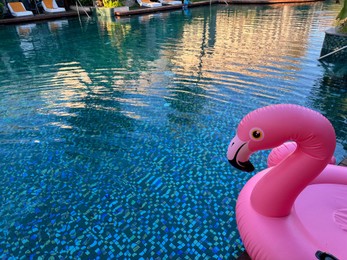 Photo of Outdoor swimming pool with clear water and inflatable float in shape of flamingo at luxury resort