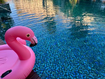 Photo of Outdoor swimming pool with clear water and inflatable float in shape of flamingo at luxury resort