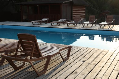 Photo of Outdoor swimming pool with clear water, sunbeds and house