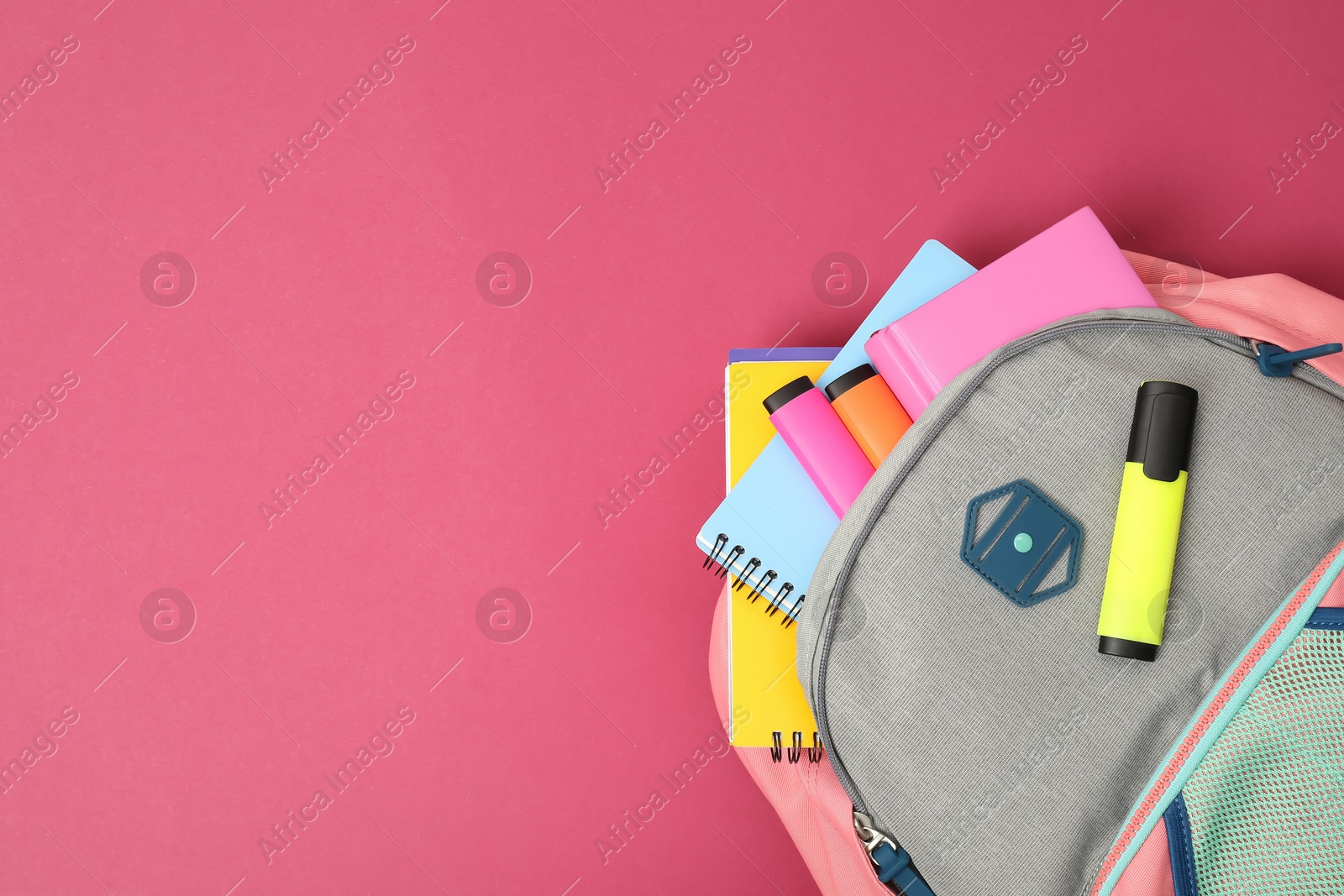 Photo of Backpack with different school supplies on pink background, top view. Space for text