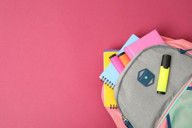 Photo of Backpack with different school supplies on pink background, top view. Space for text