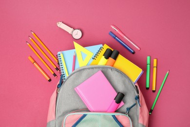 Photo of Backpack and different school supplies on pink background, flat lay