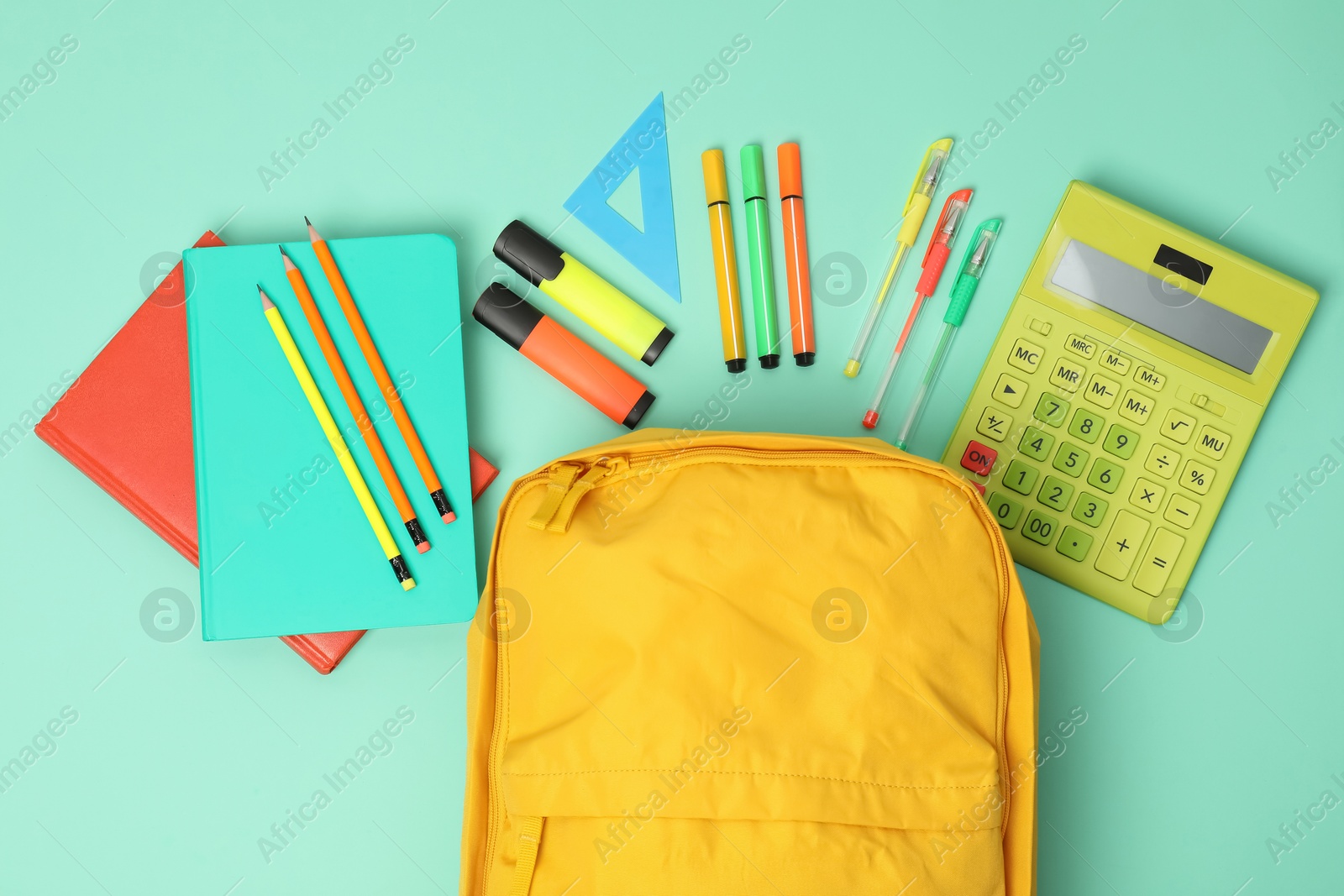 Photo of Backpack and different school supplies on turquoise background, flat lay